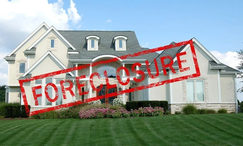 A beautiful suburban home marked with a bold "FORECLOSURE" stamp, highlighting its distressing financial situation.