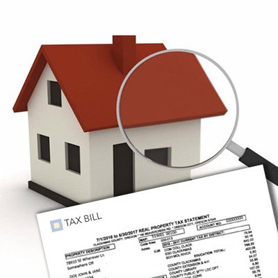 A small house model with a magnifying glass over a property tax bill, emphasizing the importance of property taxes.