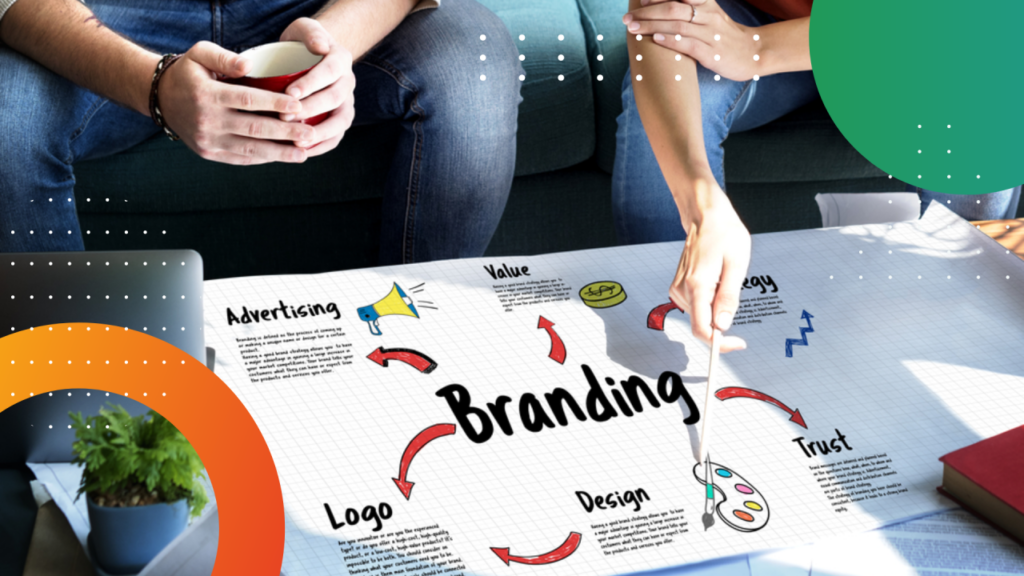 Two people sit at a table with a marketing chart labeled Branding that highlights Advertising, Value, Strategy, Trust Elements, Design, and Logo. One person points at the chart with a pen as colorful shapes and visual proof decorate the image.